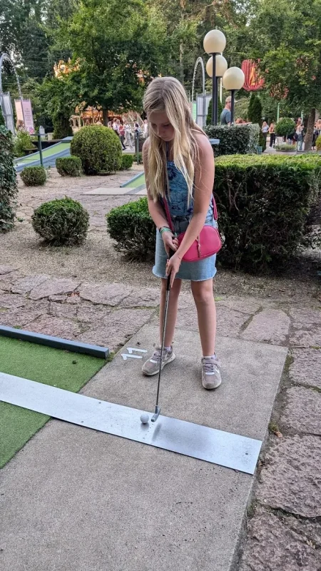 Et barn slår ud på minigolfbanen i Tivoli Friheden